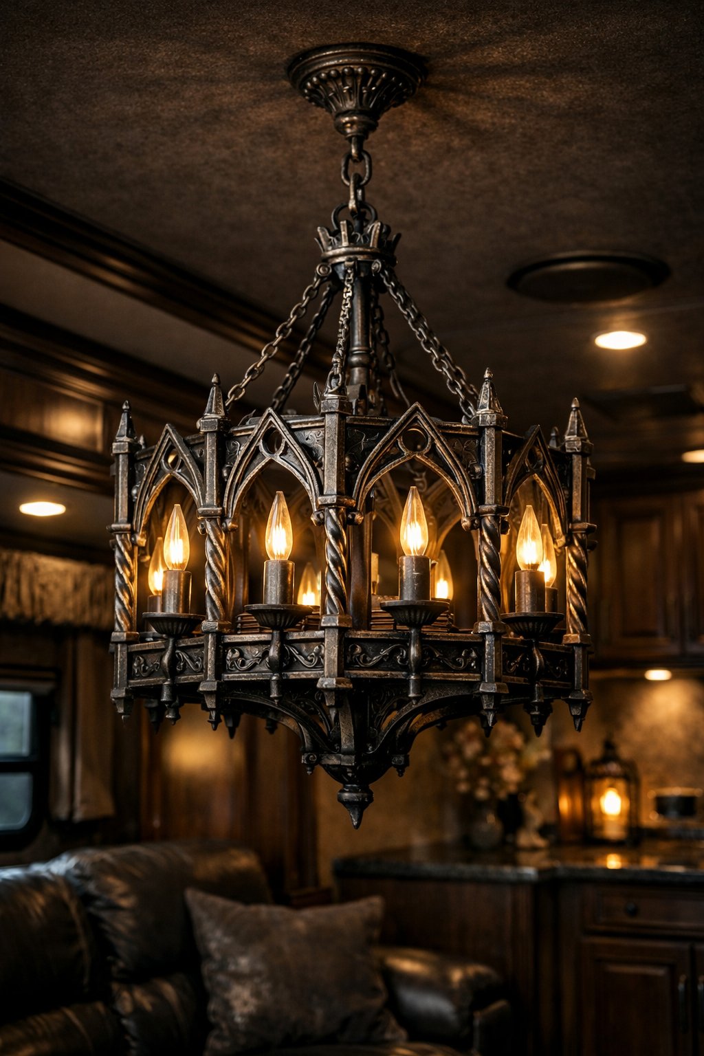 Metallic iron chandelier hanging inside a dark RV interior with stylish furnishings.