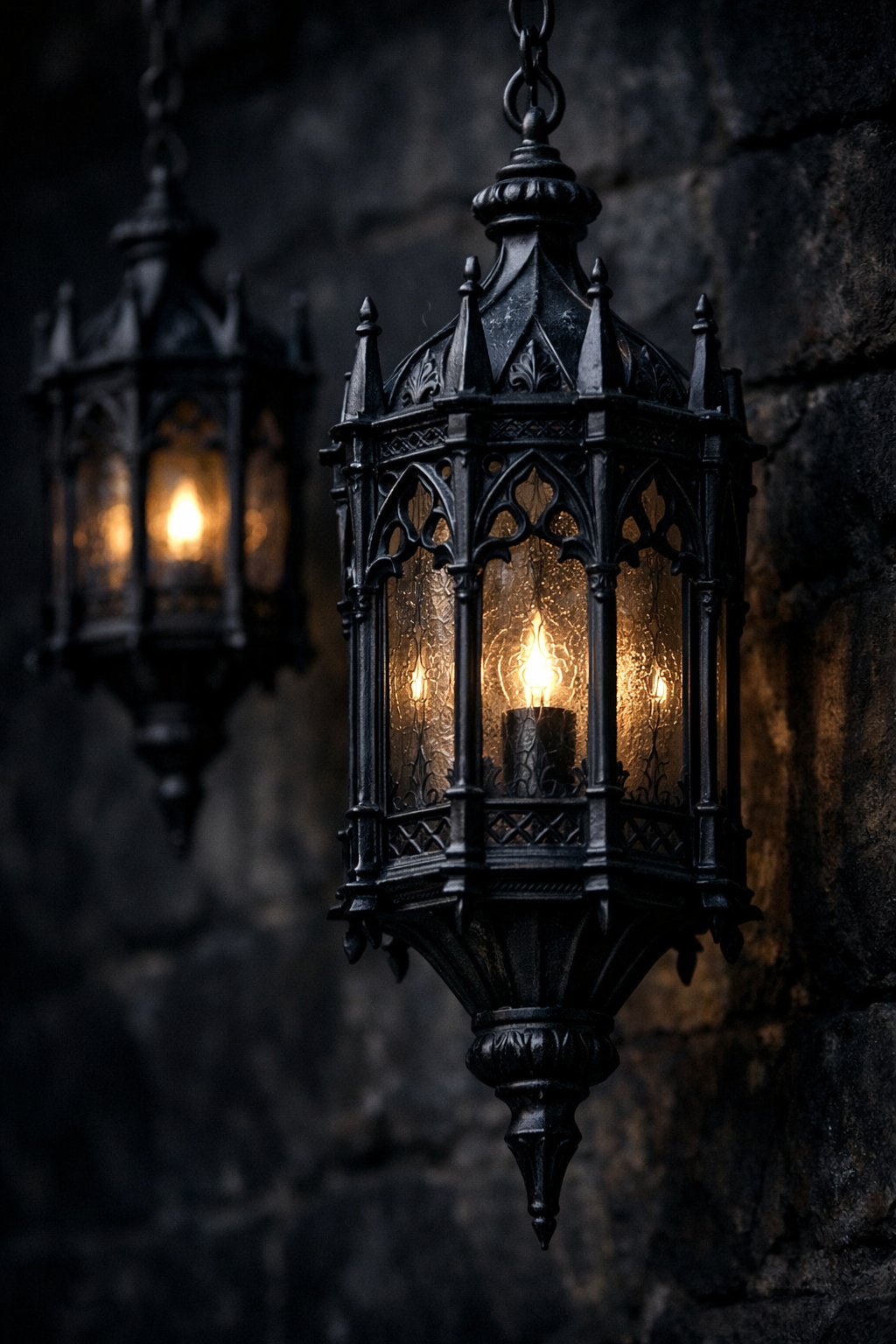 Close-up of black iron lanterns with intricate designs hanging outdoors against a dark background.