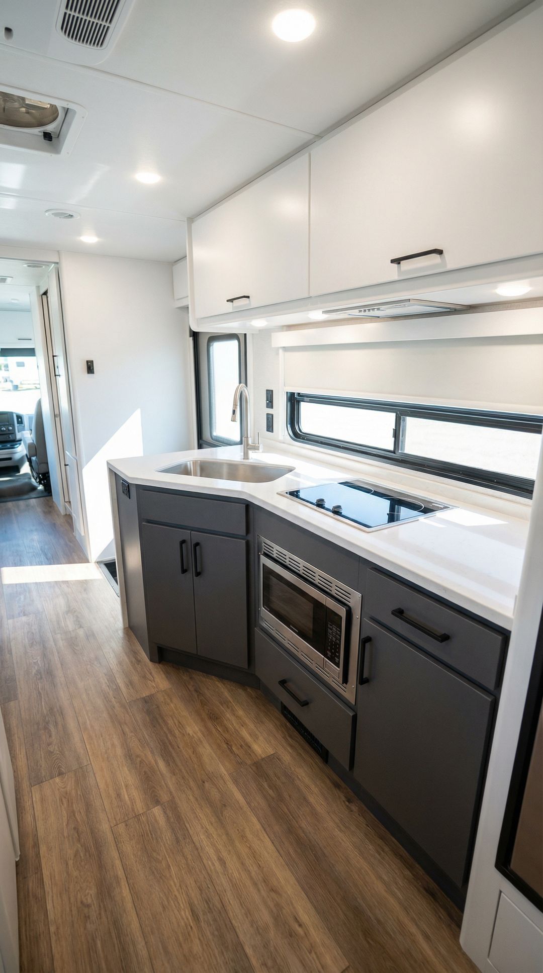 Modern RV interior with wood-look luxury vinyl plank flooring throughout the space
