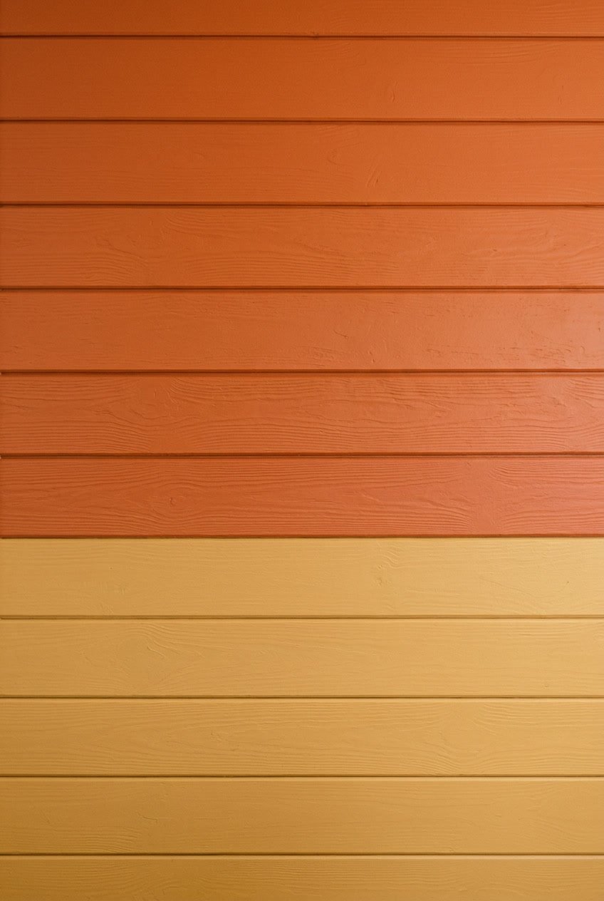 Interior camper wall with two-tone shiplap panels in sunset orange and soft yellow colors.